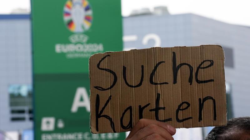 UEFA warnt vor illegalem Kauf von EM-Tickets Ein Schild mit der Aufschrift "Suche Karten" wird hochgehalten.