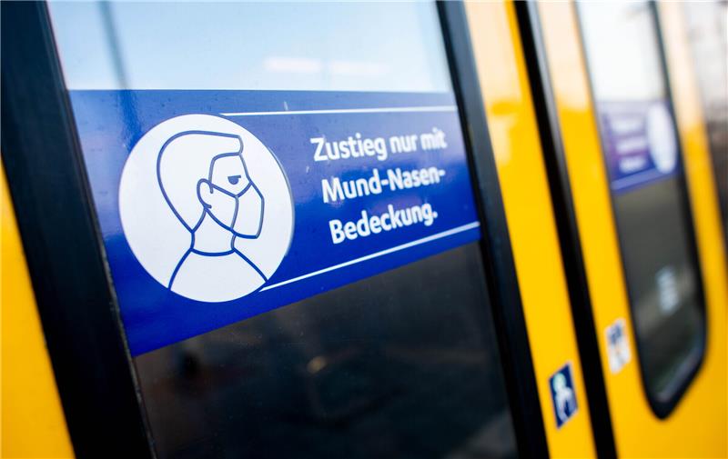 Ein Schild mit der Aufschrift "Zustieg nur mit Mund-Nasen-Bedeckung" klebt an der Zugtür einer S-Bahn. Foto: Hauke-Christian Dittrich/dpa