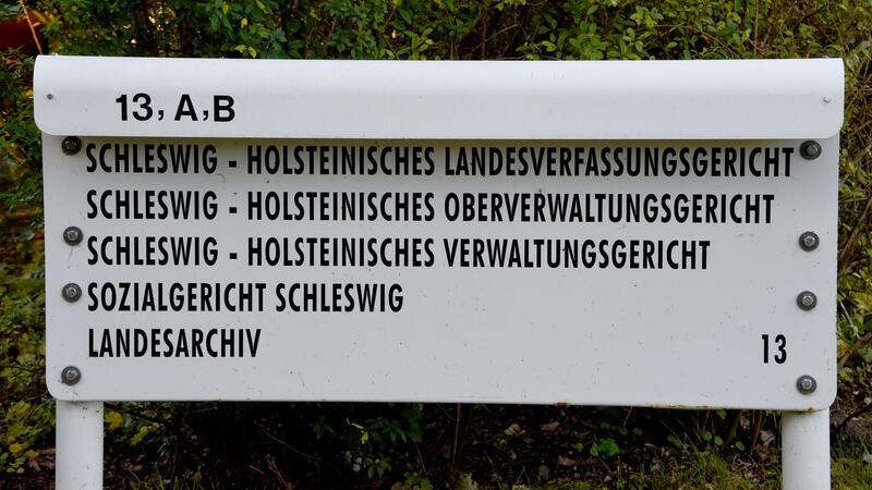 Ein Schild steht am Eingang zum schleswig-holsteinischen Landesverfassungsgericht, Oberverwaltungsgericht, Verwaltungsgericht und Sozialgericht.