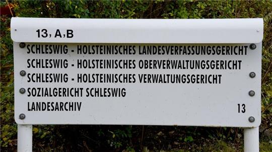 Ein Schild steht am Eingang zum schleswig-holsteinischen Landesverfassungsgericht, Oberverwaltungsgericht, Verwaltungsgericht und Sozialgericht.