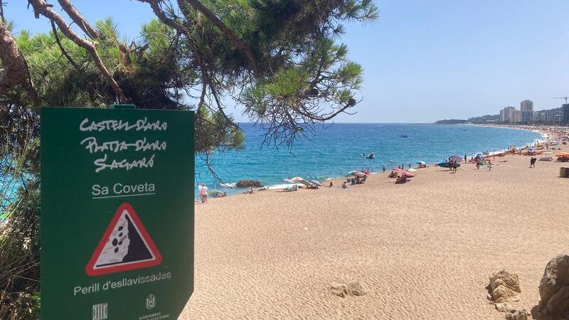 „Der Strand ist weg“ - Spaniens Küsten leiden Ein Schild weist an der Platja Gran, dem „Großen Strand“, auf Steinschlag hin.