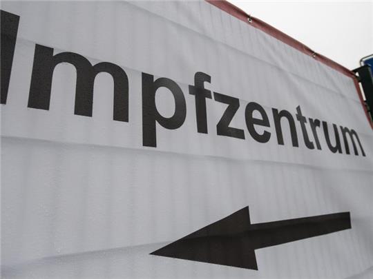Ein Schild weist den Weg zu einem Impfzentrum. Foto: Boris Roessler/dpa/Symbolbild