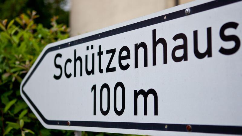 Ein Schild weist den Weg zu einem Schützenhaus.