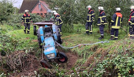 Ein Schlepper zieht den Trecker aus dem Graben. Ein Erntehelfer hat am Mittwochmorgen bei einem Unfall in Jork sein Leben verloren. Foto: Vasel