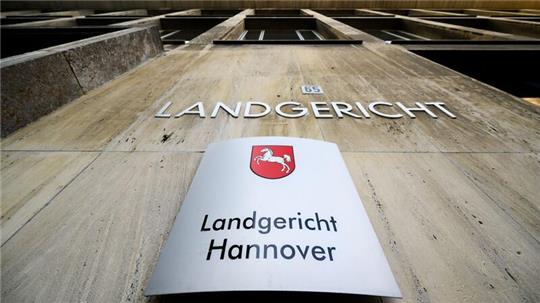Ein Schriftzug und ein Schild hängen am Landgericht Hannover.