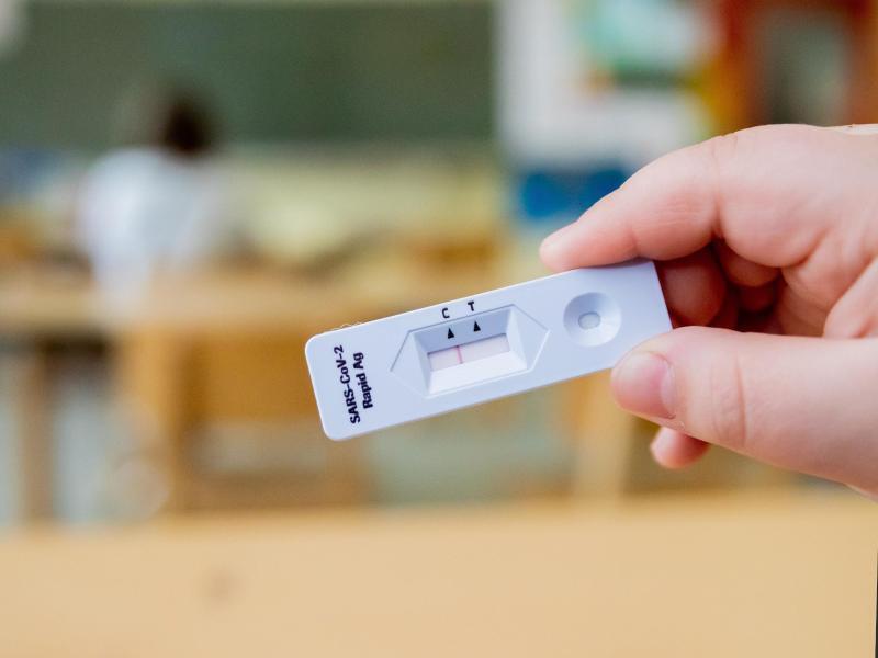 Ein Schüler hält einen negativen Corona-Schnelltest in der Hand. Foto: Christoph Soeder/dpa/Symbolbild