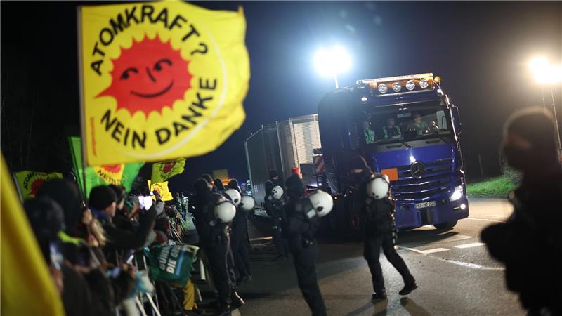 Ein Schwertransporter mit einem Castor-Behälter fährt an Teilnehmer einer Anti-Atomkraft-Demonstration vorbei.