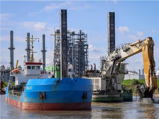 Ein Schwimmbagger holt auf der Baustelle des LNG Terminals an der Elbe in Stade Klei aus dem neuen Hafenbecken. Die Klei wird an der Schwingemündung gelagert. Foto: Focke Strangmann/dpa