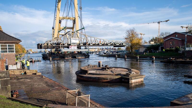 Ein Schwimmkran hebt die Deichbrücke im Jahr 2020 an. Die über 100 Jahre alte Drehbrücke wird mit einem Schwimmkran ausgehoben und zur Instandsetzung zum Hannoverkai transportiert.
