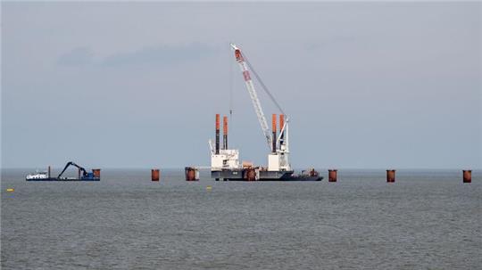 Ein Schwimmkran ist während der Bauarbeiten für einen Anleger, der für ein zweites LNG-Terminal in Wilhelmshaven benötigt wird, im Einsatz.