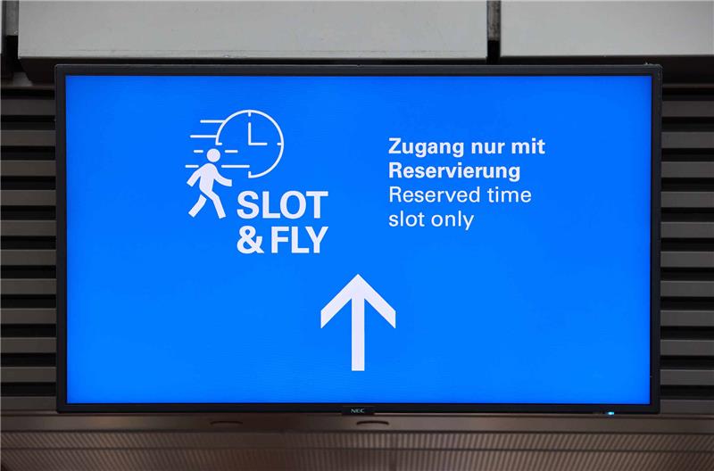 „Slot and Fly“ soll Situation am Hamburger Flughafen entspannen Ein Screen mit der Aufschrift "Slot &Fly - Zugang nur mit Reservierung" ist am Hamburger Flughafen zu sehen. Jeder Passagier hat künftig die Möglichkeit, sich kostenlos einen 15-Minuten-Zeitslot für einen separaten Zugang zur Sicherheitskontrolle zu reservieren. Foto: Georg Wendt/dpa