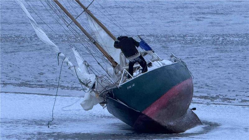 Ein Skipper sitzt vor Grünendeich mit seinem Segelboot auf einer Sandbank in der Elbe fest.