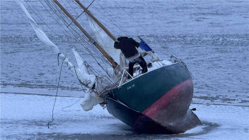 Ein Skipper sitzt vor Grünendeich mit seinem Segelboot auf einer Sandbank in der Elbe fest.