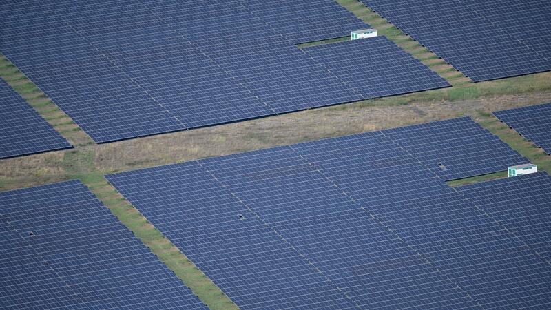 Ein Solarpark wird von der Sonne angeschienen.