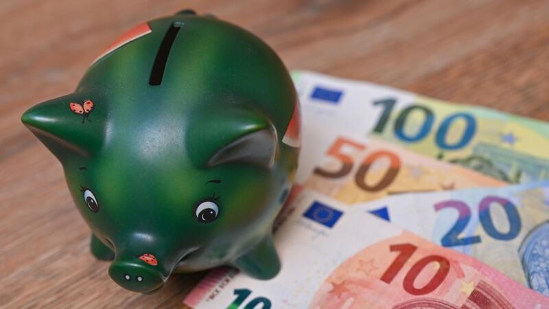 Ein Sparschwein steht auf einem Tisch neben Eurobanknoten. Foto: dpa