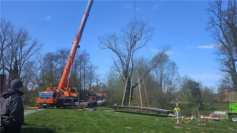 Ein Spezialkran setzte die 2,9 Tonnen schwere Brücke an der Burginsel in Horneburg ein. Die Konstruktion passte knapp durch das Schlosstor am alten Zollhaus.