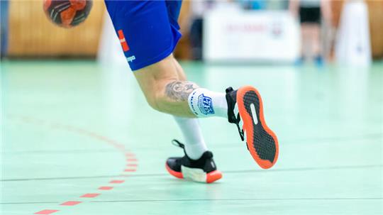Ein Spieler läuft mit einem Handball über das Spielfeld (Symbolbild).