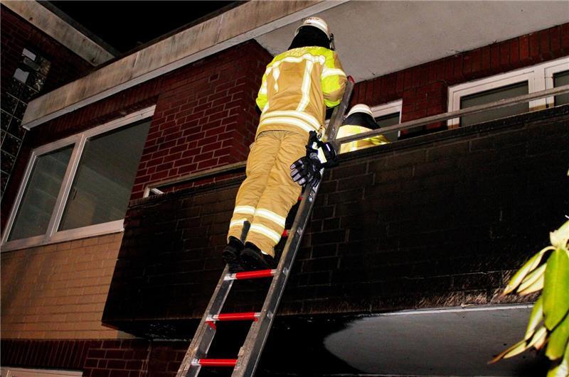 Ein Stader Feuerwehrmann untersucht den über der Brandstelle liegenden Balkon auf mögliche Schäden.