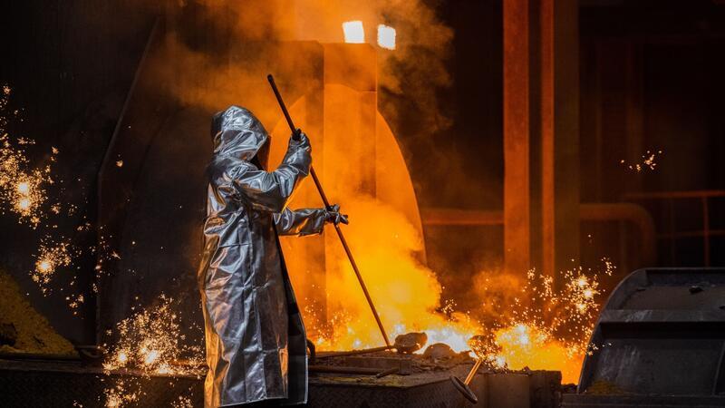 Erzeugerpreise fallen wieder deutlicher Ein Stahlarbeiter an einem Hochofen: Die Erzeugerpreise erfassen den Preisdruck auf Herstellerebene.