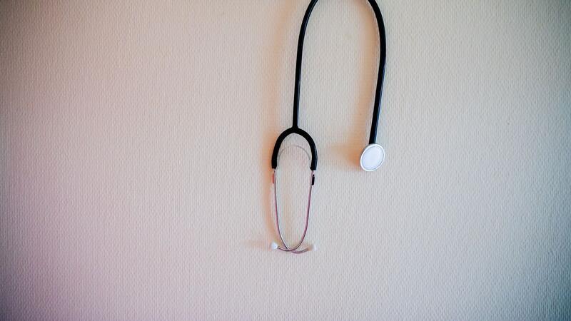 Ein Stethoskop hängt an einer Garderobe.