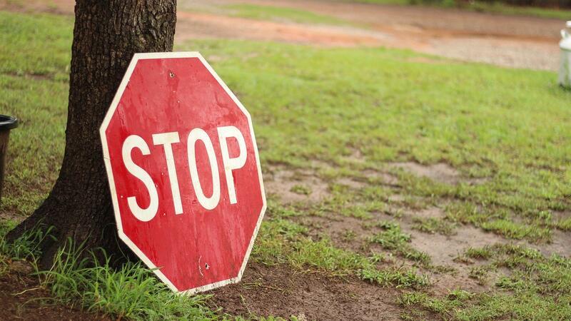 Gesperrte Straße in Stade befahren: Anwohner gibt sich als Polizist aus und hält Autos an Ein Stoppschild lehnt an einem Baum.