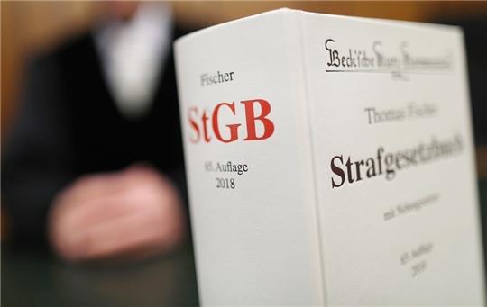 Ein Strafgesetzbuch (StGB) steht auf der Richterbank. Foto: Oliver Berg/dpa