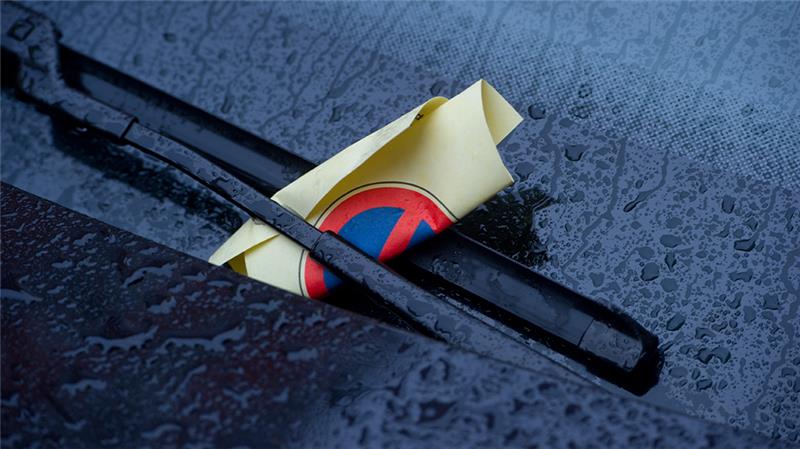 Ein Strafzettel (Knöllchen) steckt unter einem Scheibenwischer eines geparkten Autos. Foto: Stefan Sauer