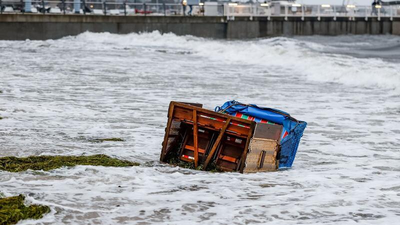 Ein Strandkorb wird in Kiel-Schilksee von den Flutwellen der Ostsee weggespült.