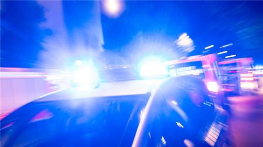 Ein Streifenwagen der Polizei steht mit Blaulicht an einem Einsatzort.