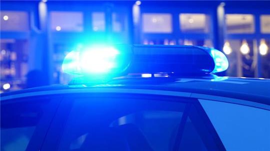 Ein Streifenwagen der Polizei steht mit eingeschaltetem Blaulicht an einem Einsatzort.