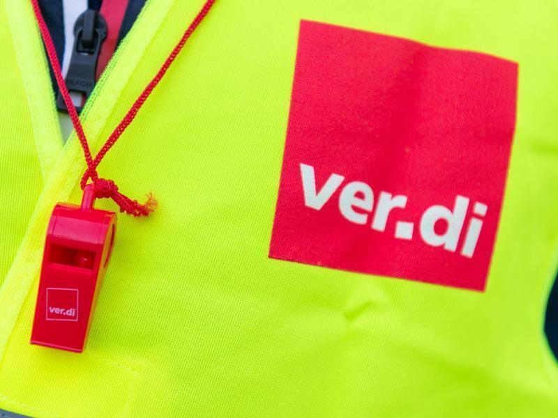 Tarifstreit im Groß- und Außenhandel hält an Ein Streikender trägt eine Warnweste mit dem Verdi-Logo. Foto: Christophe Gateau/dpa/Archivbild
