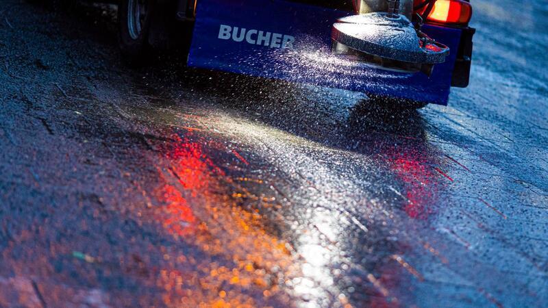 Ein Streufahrzeug verteilt Streumittel auf der Straße.