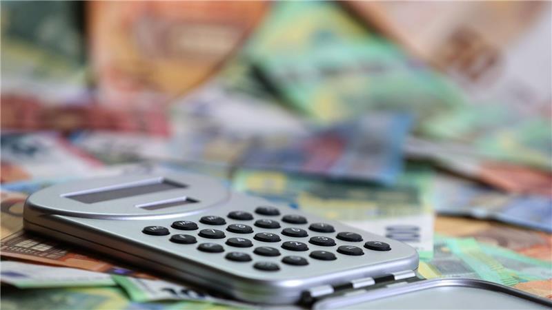 Ein Taschenrechner liegt auf verschiedenen Euro-Banknoten. (Symbolbild)