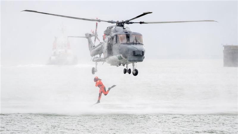 Bilder des Tages Ein Taucher springt im Rahmen einer Vorführung auf dem Marinestützpunkt Wilhelmshaven aus einem Hubschrauber.