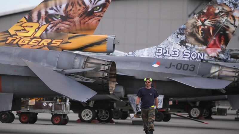 Ein Techniker läuft in Jagel zwischen den Leitwerken von F-16 Kampfflugzeugen entlang.