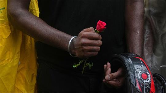 Ein Teilnehmer einer Demonstration hält während einer Kundgebung für Bildungsreformen im Rahmen der anhaltenden Protestbewegung der „Cockroach Janta Party“ eine Blume in der Hand.