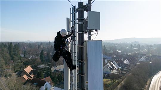 Ein Telekom-Techniker an einem Mobilfunk-Masten - an so einem Standort könnten künftig auch Anti-Drohnen-Sensoren hängen. (Archivbild)