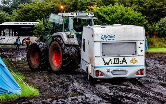 Ein Traktor zieht einen Wohnwagen vom verschlammten Campinggelände des Wacken Open Air. Nach vier Tagen Heavy-Metal-Party verlassen zehntausende Metalfans den Norden. Foto: Axel Heimken/dpa