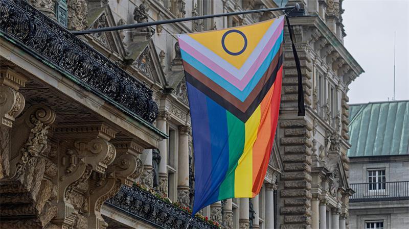 Ein Trauerflor ist an der Pride-Fahne vor dem Hamburger Rathaus angebracht.