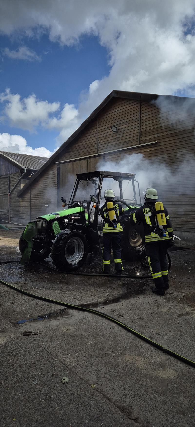 Brände: Traktor am Deich auf Krautsand in Flammen Ein Trupp der Freiwilligen Feuerwehr Schiffdorf unter Atemschutz während der Löscharbeiten.