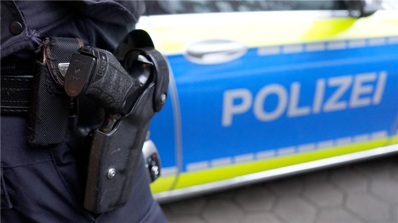 Buxtehude: Räuber sticht in Tiefgarage auf Mann ein Ein Polizist steht vor einem Streifenwagen.