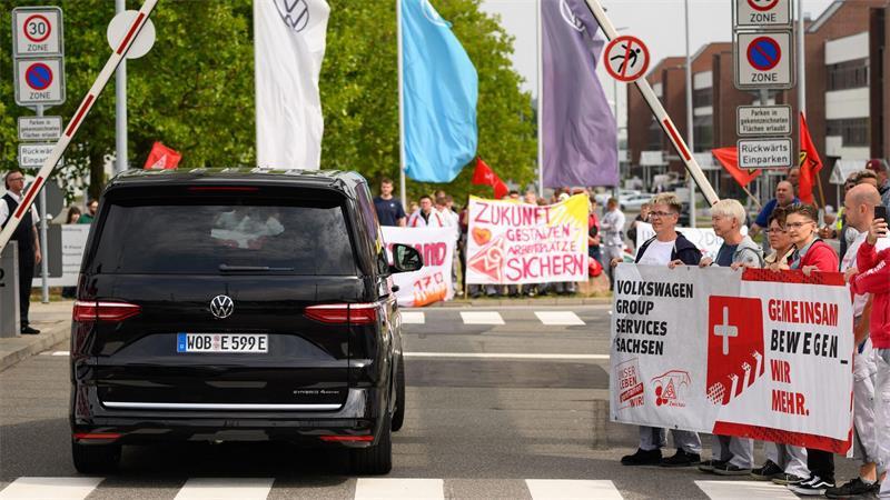 VW-Chef: Kosten zu hoch - Einschnitte im Management Ein VW-Bus mit VW-Vorstandschef Oliver Blume passiert die Demonstration von Beschäftigten am Werkstor des Standortes Zwickau.