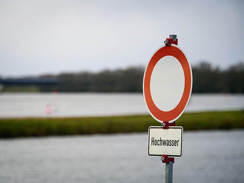 Ein Verkehrsschild mit der Aufschrift „Verbot für Fahrzeuge aller Art“ mit dem Zusatz „Hochwasser“ steht am Ufer der Elbe. Foto: Soeren Stache/dpa-Zentralbild/dpa
