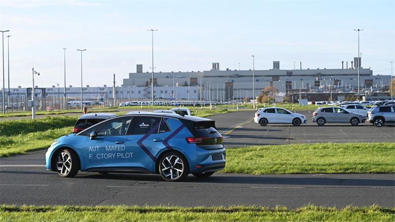 Ein Volkswagen-Fahrzeug fährt autonom über das Werksgelände.