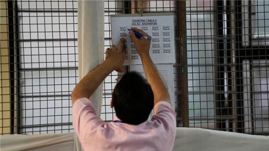 Ein Wahlhelfer markiert eine Tabelle nach der ersten Runde der Stimmenauszählung in einem Auszählungszentrum in Neu-Delhi.
