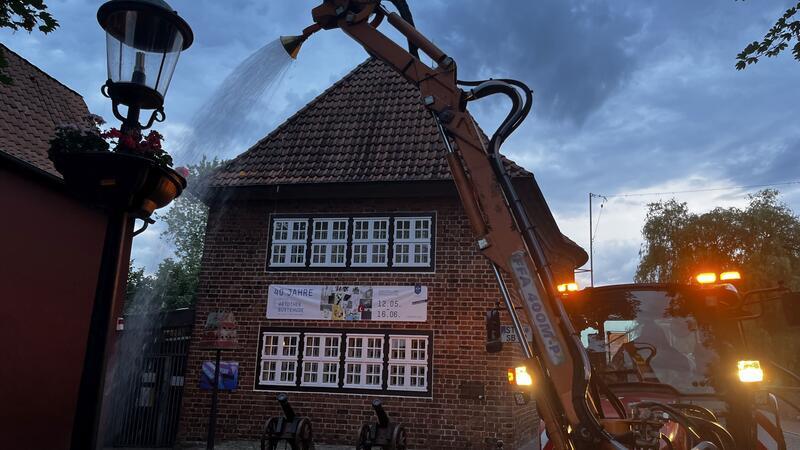 Die grüne Hölle von Buxtehude: Unterwegs mit den Grünpflegern der Stadt Ein Wasserschwall ergießt sich über die Blumenampel am Fleth.