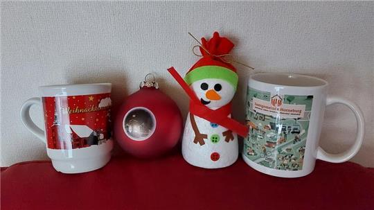 Ein Weihnachtsbecher, eine rote Weihnachtskugel, ein Styropor-Schneemann und ein Wimmelbecher werden in vier Geschäften in Horneburg versteckt.