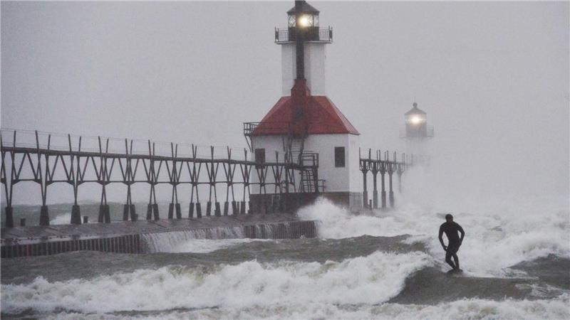 Ein Wellenreiter surft durch wehenden Schnee.