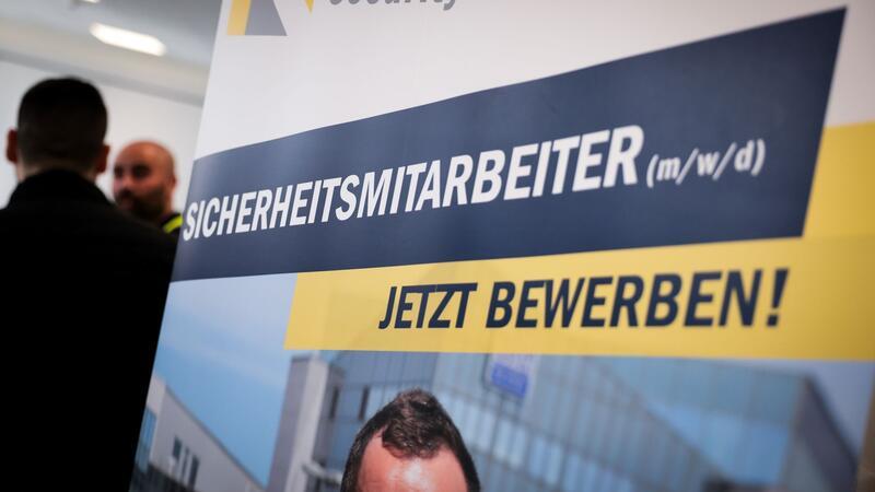 Ein Werbebanner eines Sicherheitsunternehmens steht auf der Jobbörse der Sicherheitsbranche.