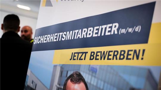 Ein Werbebanner eines Sicherheitsunternehmens steht auf der Jobbörse der Sicherheitsbranche.